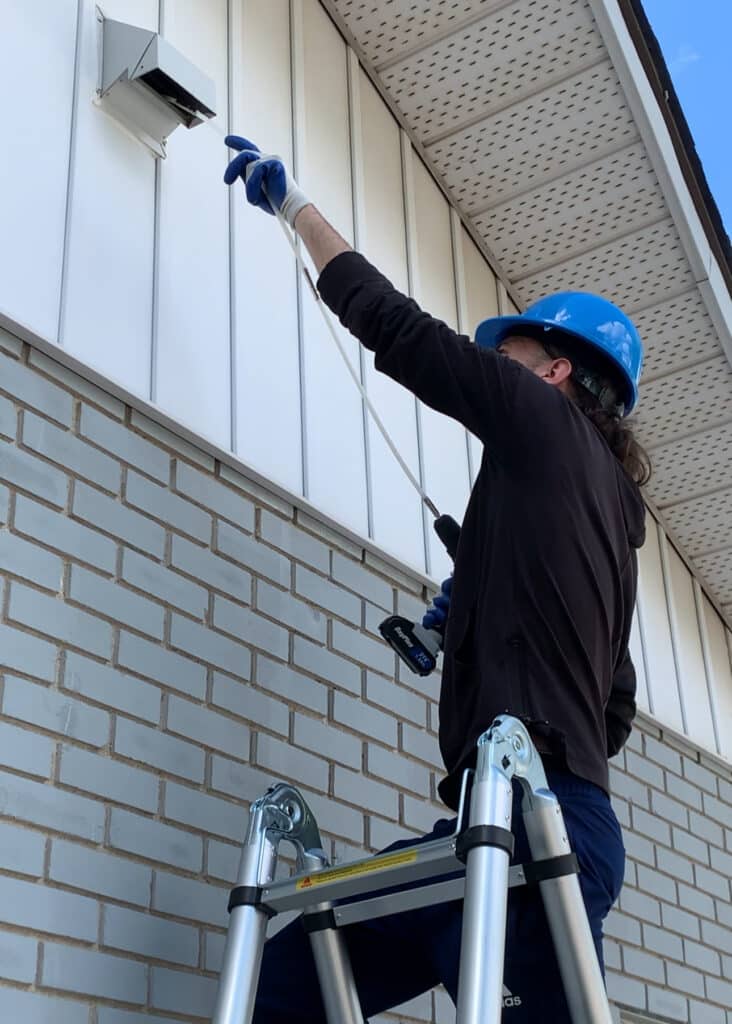 Technician cleaning dryer vent in Laval.