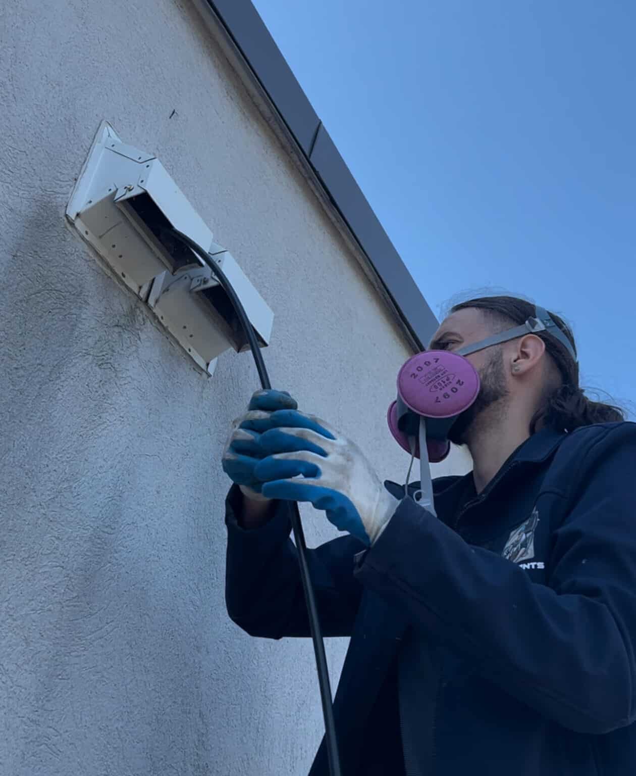 Technician Cleaning Dryer Vent in Laval