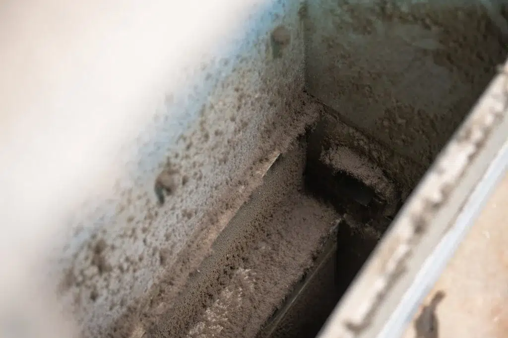 Technician inspecting dusty air duct interior