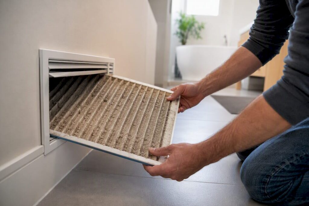 Replacing dusty HVAC air filter near vent