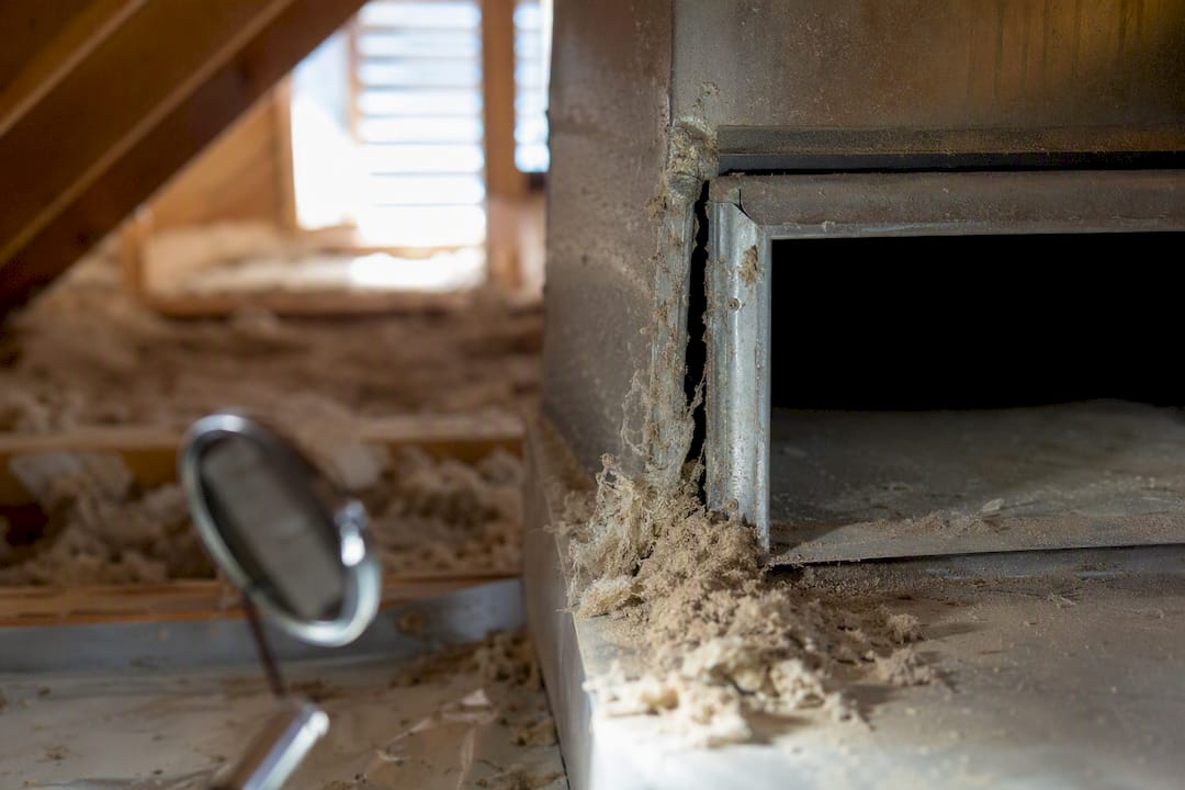 Cracked return duct seam in attic with dust